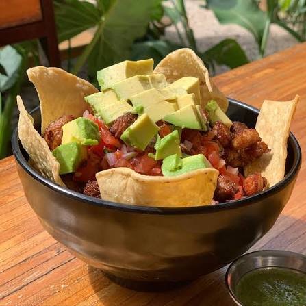 Chifrijo con tortillas de maíz fritas y tostadas, pico de gallo y aguacate