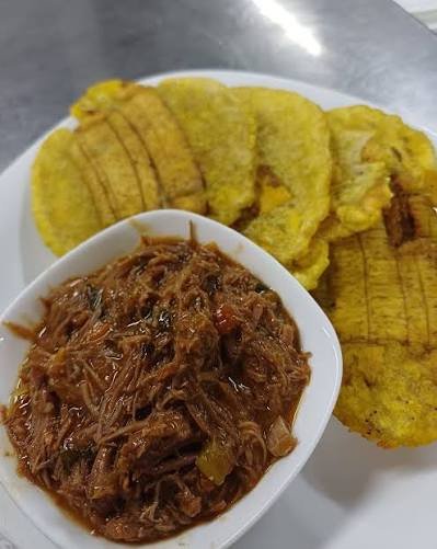 Porción de patacones con carne mechada en salsa